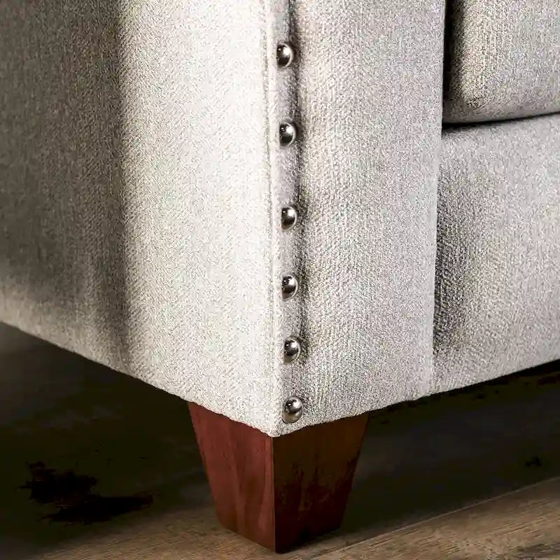 Canapé en tissu gris clair, orné de rivets